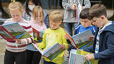 Kinder schauen in das Naturbuch des Landkreises Aurich