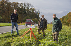 Auf dem Foto sehen Sie (v. l. n. r.): Matthias Heeren vom Ordnungsamt des Landkreis Aurich, Kreisjägermeister Dr. Peter Lienau und Ralf Dirks von der Jagdverwaltung Lütetsburg bei der Markierung einer Wildunfallstelle mit einem orangen Dreibein.