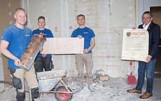 Mitarbeiter der Baufirma und Landrat Olaf Meinen mit der Zeitkapsel