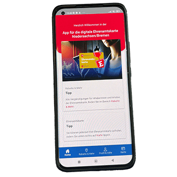 Ein Smartphone zeigt die Startseite der App für die digitale Ehrenamtskarte Niedersachsen/Bremen. Auf dem Bildschirm sind Hinweise zur Nutzung der Ehrenamtskarte sowie eine Navigationsleiste mit Symbolen für Start, Vorteile, Profil und Karte zu sehen.