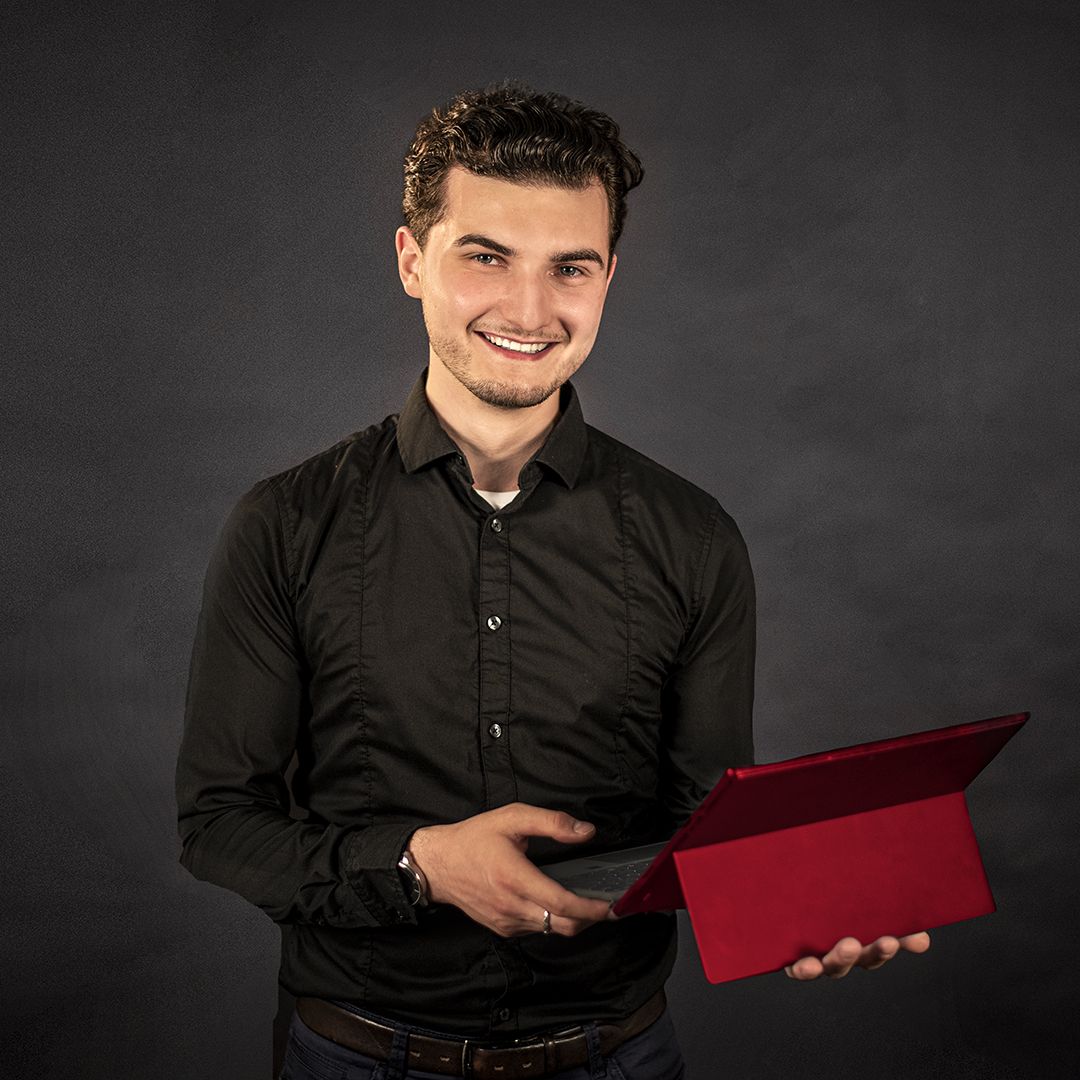 Auszubildender zum Fachinformatiker hält einen Laptop