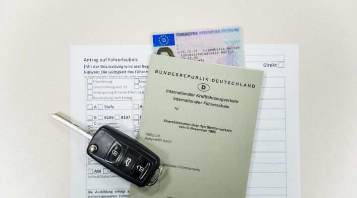 Antragsformular für eine Fahrerlaubnis mit einem Autoschlüssel, einem deutschen Kartenführerschein und einem internationalen Führerschein (Bundesrepublik Deutschland) auf weißem Hintergrund.