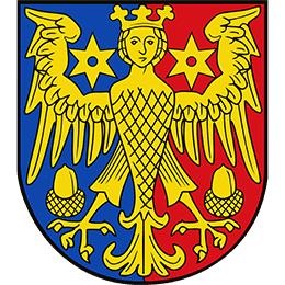 Wappen des Landkreises Aurich. Wappen mit einem goldenen, gekrönten Adler mit ausgebreiteten Flügeln auf einem senkrecht zweigeteilten Hintergrund in Blau (links) und Rot (rechts). Auf jeder Seite befindet sich ein sechszackiger Stern in der jeweils anderen Farbe. Unter den Flügeln sind zwei goldene Eicheln dargestellt.