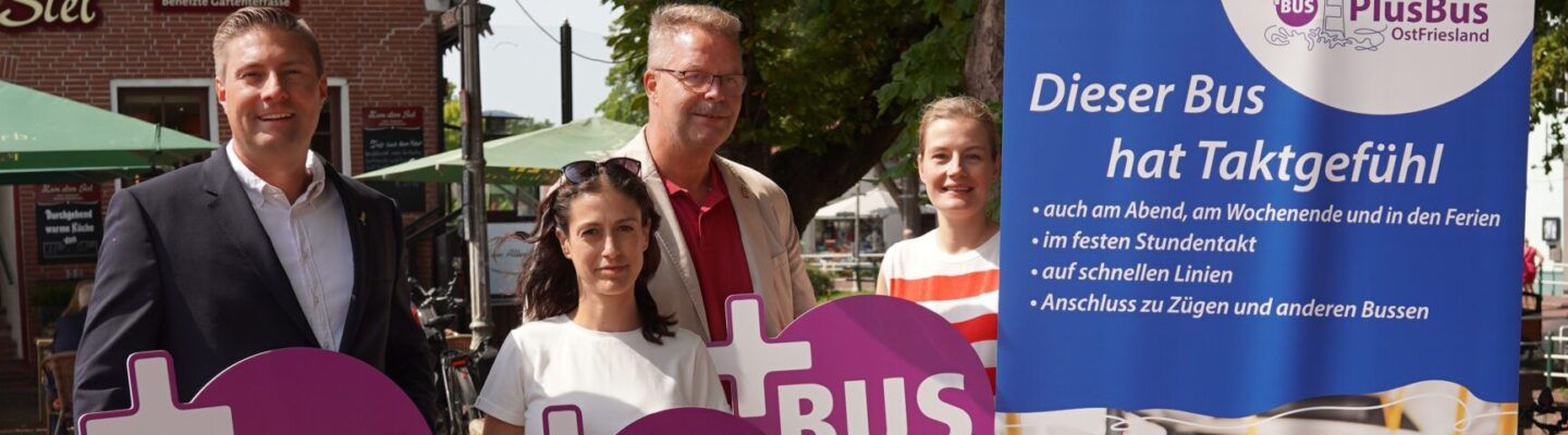 Gruppe von Menschen in Greetsiel, mit Schildern vom PlusBus in der Hand