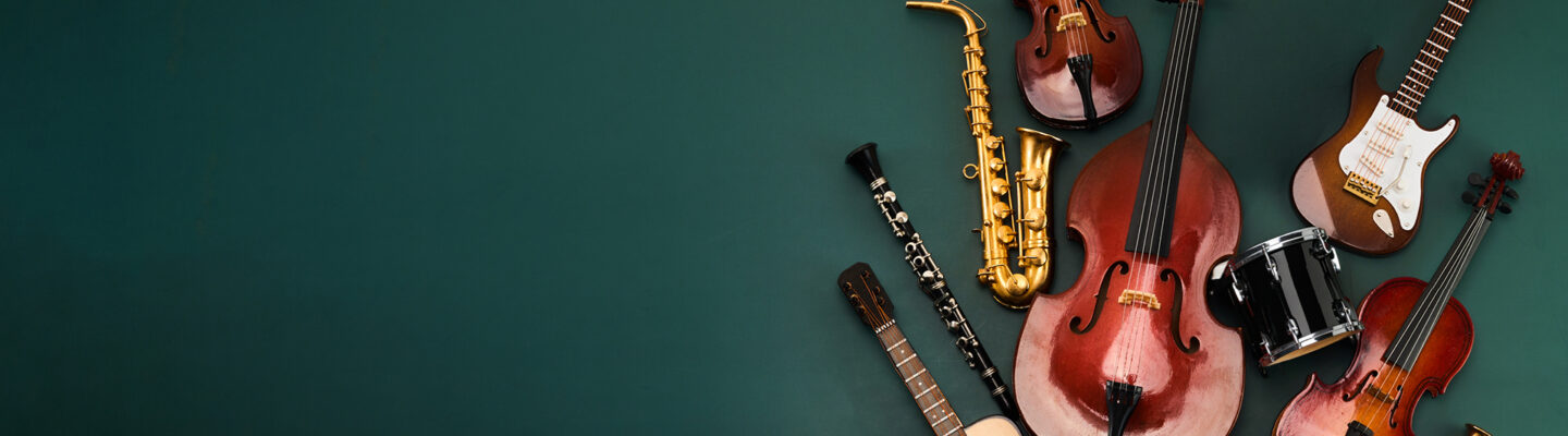 Das Bild zeigt eine dekorative Anordnung verschiedener Musikinstrumente vor einem dunkelgrünen Hintergrund. Zu sehen sind unter anderem ein Kontrabass, zwei Violinen, ein Saxophon, eine Klarinette, eine Gitarre, eine E-Gitarre, ein Akkordeon, eine Trommel, eine Trompete sowie ein Horn. Die Instrumente sind auf der rechten Bildseite gruppiert, während die linke Seite viel freie Fläche bietet.