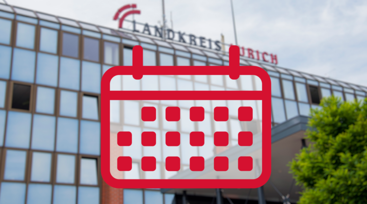 Unscharfe Außenaufnahme des Kreishauses des Landkreises Aurich. Im Vordergrund ist groß ein rotes Kalendersymbol eingeblendet, das auf Termine oder Veranstaltungen hinweist.